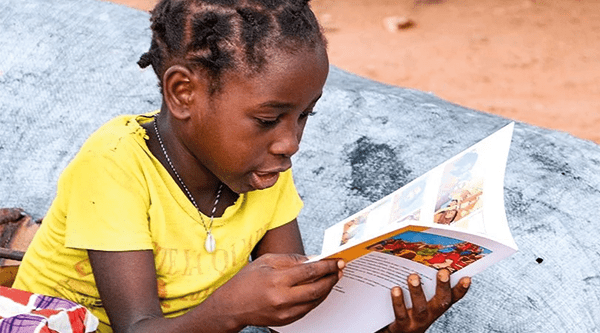 Dziewczynka z Mozambiku czyta Biblię dla dzieci